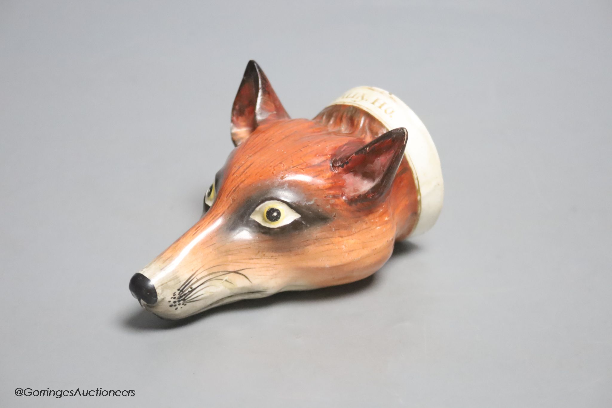 An early 19th century English porcelain 'Tally Ho' fox head stirrup cup, length 11cm